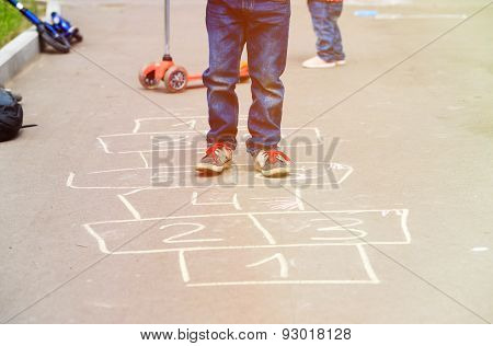 kids playing hopscotch on playground outdoors