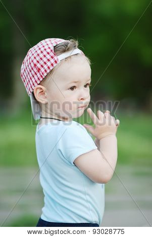 Baby Boy In A Plaid Cap On A Green Background