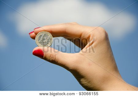 Coin in the hands against the sky