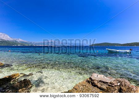 blue beach at Korcula Croatia with boat and swimmers