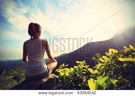 young yoga woman at sunrise mountain peak