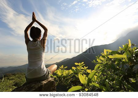 young yoga woman at sunrise mountain peak