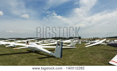 gliders at green airfield with blue sky