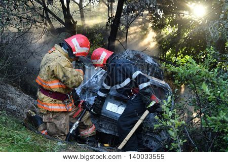 TULCEA, ROMANIA - JUNE 11: Danube Delta Rally special trial windfarm on June 11, 2016 in Tulcea, Romania; car on fire and firemen trying to estinguish fire