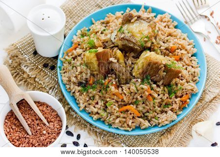 Pilaf from rice devzira with lamb spices and vegetables. Traditional pilaf on the table with ingredients selective focus