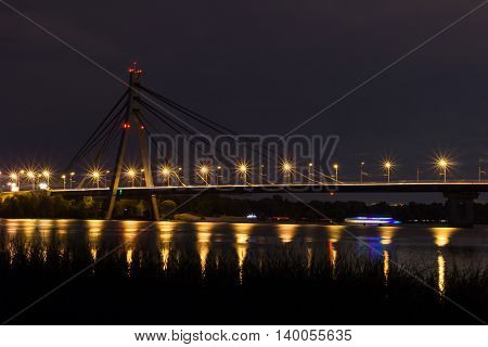Night bridge above river with reflecting lights