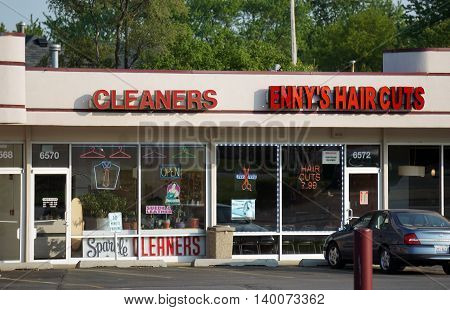 COUNTRYSIDE, ILLINOIS / UNITED STATES - MAY 21, 2016: One may have one's clothes cleaned at Sparkle Cleaners, and have one's hair cut at Enny's Haircuts, in a strip mall in Countryside, Illinois.