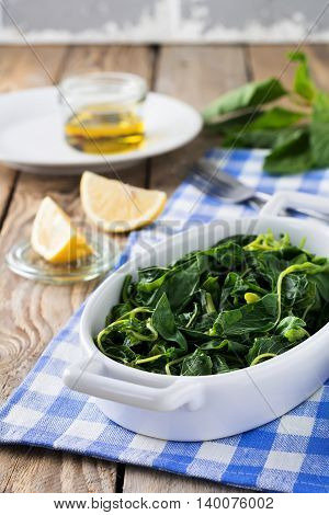 Boiled wild herbs Vlito with lemon juice and olive oil. The traditional Greek snack. Selective focus.