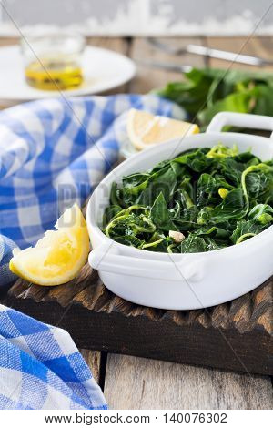 Boiled wild herbs Vlito with lemon juice and olive oil. The traditional Greek snack. Selective focus.