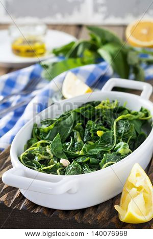 Boiled wild herbs Vlito with lemon juice and olive oil. The traditional Greek snack. Selective focus.