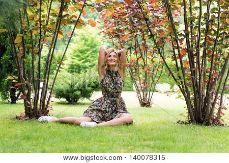 Young Woman Relaxing On A Beautiful Green Meadow.