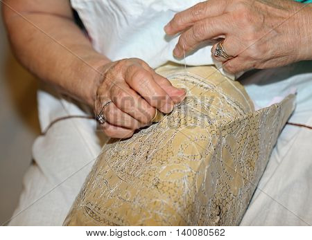 Elderly While Embroidering A Lace With Lace Pillow In Italy