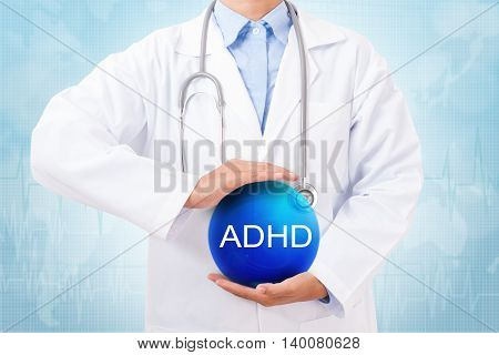 Doctor holding blue crystal ball with ADHD sign on medical background.