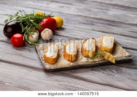 Bread slices with butter. Piece of lemon and herb. Recipe of simple appetizer. Fresh butter and grilled baguette.