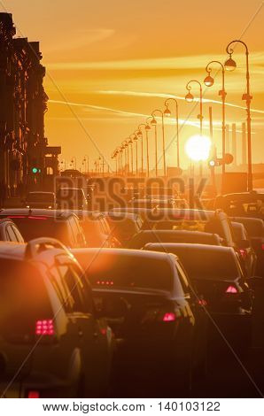Cars are in a traffic jam during a beautiful golden sunset in a big sity.