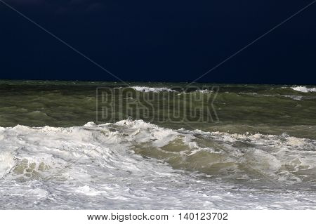 Stormy sea with waves und a dark blue sky.