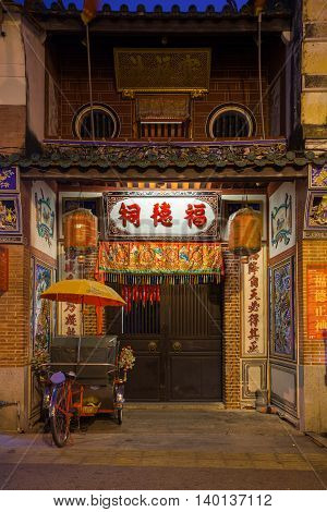Rickshaw tricycle parked near the entrance to Hock Teik Cheng Sin Temple Armenian Street George Town Penang Malaysia.
