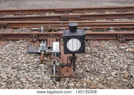 Hand-operated railroad switch with lever, weight and signal