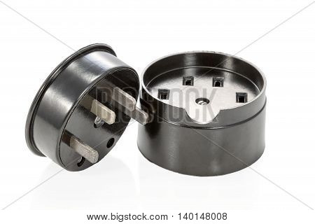 Black ceramic three-phase socket and plug lying beside isolated on white background