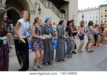 CRACOW POLAND - JULY 24 2016: Pilgrims of World Youth Day sing and dance on the Main Square in Cracow. Poland