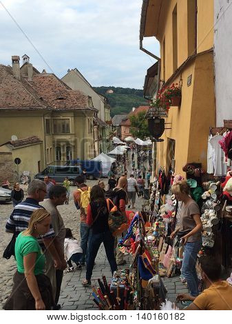 Romania, August 21, 2015, Sighisoara, Transylvania, People in an old street with small shops