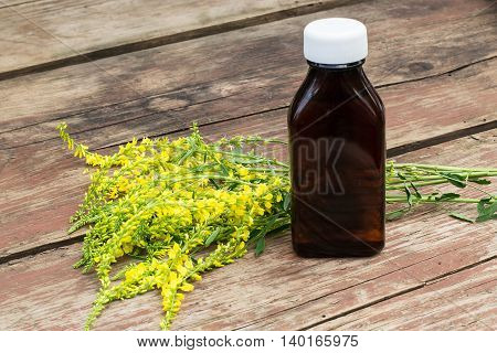 Melilotus officinalis known as yellow sweet clover yellow melilot ribbed melilot common melilot and pharmaceutical bottle on old wooden table. Used in herbal medicine as well as pasture or livestock feed is a major source of nectar