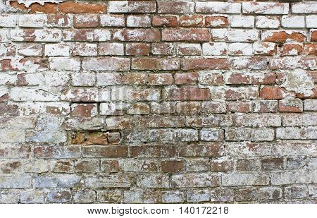Old grungy wall with white and red bricks for background. Cracked brickwall texture.