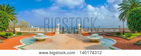 The scenicterrace in the middle Bahai Gardens decorated with the symmetric fountains flower beds and marble eagles on the hendrails Haifa Israel.