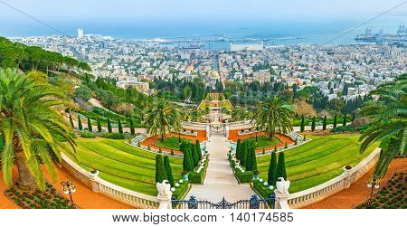 The perfectly landscaped terraced Bahai Gardens on the of Carmel Mount with the buildings of Haifa and Mediterranean coast in the distance Israel.