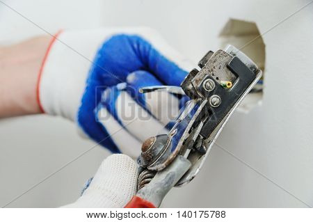 Electric stripping insulation from wire for installation an electrical outlet.