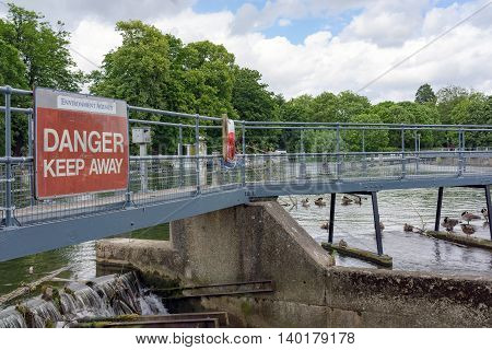 Pangbourne/UK. 10th July 2016. A Danger sign warns intruders of the dangers of trespassing on this weir on the River Thames at Pangbourne.