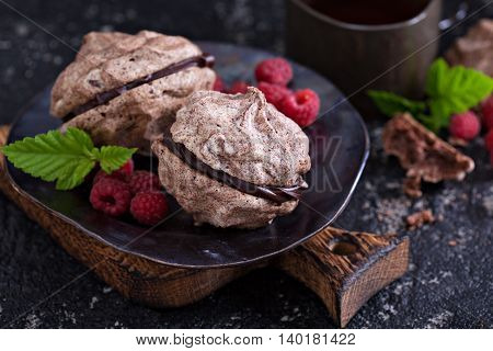 Meringue dessert with chocolate and raspberries on dark background