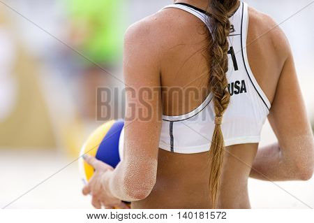 Volleyball player is a female athlete volley ball player getting ready to serve the ball.
