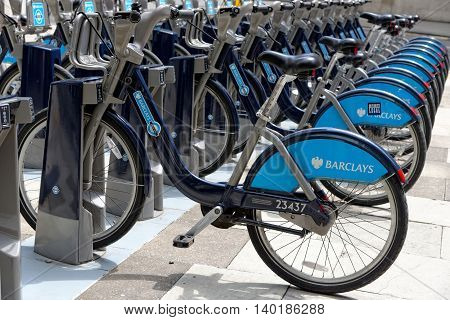LONDON ENGLAND - JULY 1 2014: Shared bikes are lined up in the streets of London. Barclays Cycle Hires launched in July 2010 has over 720 stations and 10000 bikes throughout London.