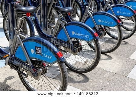 LONDON ENGLAND - JULY 1 2014: Shared bikes are lined up in the streets of London. Barclays Cycle Hires launched in July 2010 has over 720 stations and 10000 bikes throughout London.