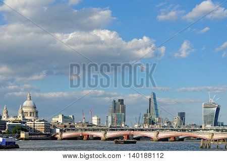 A view of Blackfriars bridge - a road and foot traffic bridge over the river Thames against a background of St Paul Cathedral the City and the Blackfriars railway bridge.