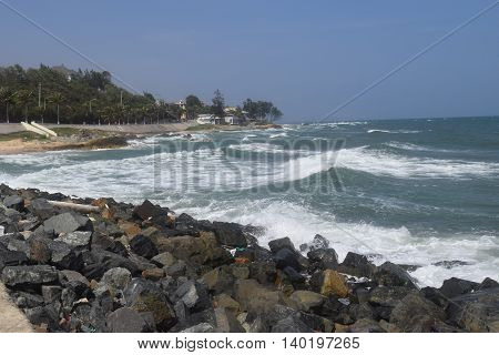 beautiful tropical beach with strong wave and building on the shore in muine vietnam