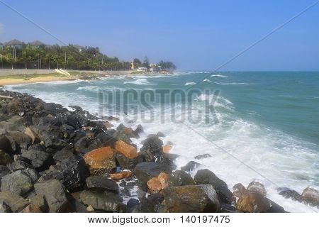 beautiful tropical beach with strong wave and building on the shore in muine vietnam