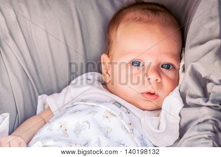 Portrait Of Cute 4-Month Baby Boy With Powerful Blue Eyes Sitting In Stroller