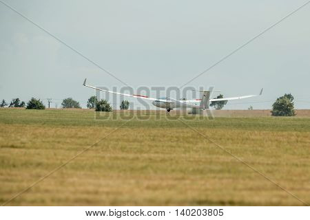 The glider landed on the grassy airport