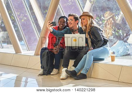 Mixed Race Group Of Students Entrepeneurs Taking Selfies Around A Laptop