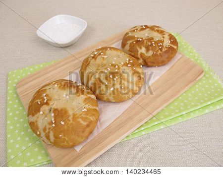 Homemade lye rolls covered with salt on wooden board