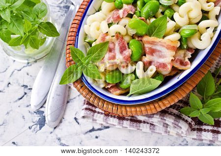 Pasta with bacon and vegetables in portion plate. Selective focus.