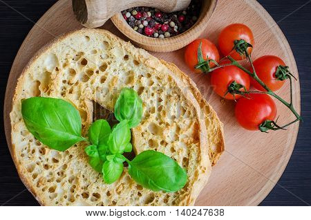 Italian dried bread Friselle on wooden board with tomatoes cherry basil and pepper. Italian food. Healthy vegetarian food.