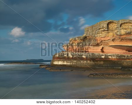 Long exposure shot on amazing pink rocks and sea