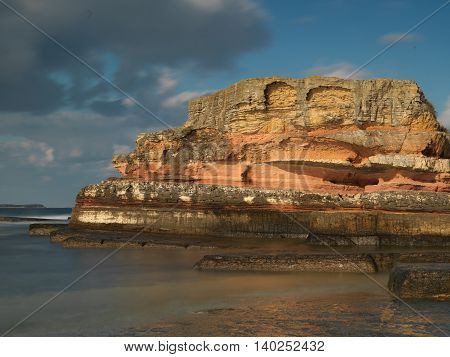 Long exposure shot on amazing pink rocks and sea