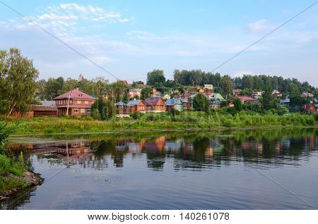 View of quiet provincial town of Ples on shore of pond in summer twilight Russia