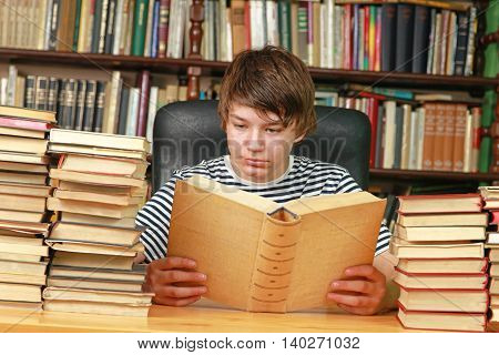 Teenage Boy Reading Book in School Library
