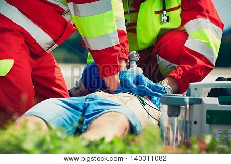 Cardiopulmonary resuscitation. Rescue team (doctor and a paramedic) resuscitating the man on the street.