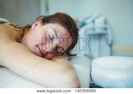 Woman relaxing on examination bed while taking massage in clinic